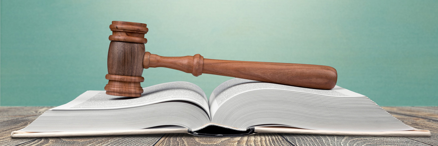 Ein Gerichtshammer liegt auf einem Gesetzbuch
