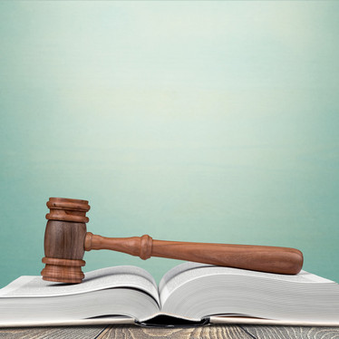 Ein Richterhammer liegt auf einem Gesetzbuch